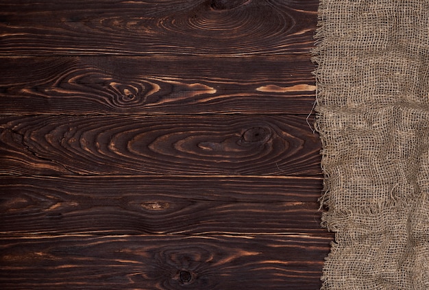 Antiguo tejido de arpillera sobre superficie de madera marrón