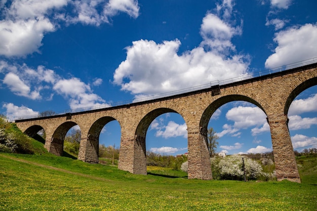 Antiguo viaducto ferroviario de piedra en primavera en un día soleado