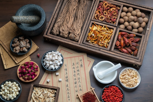 Foto antiguos libros de medicina china y hierbas sobre la mesa