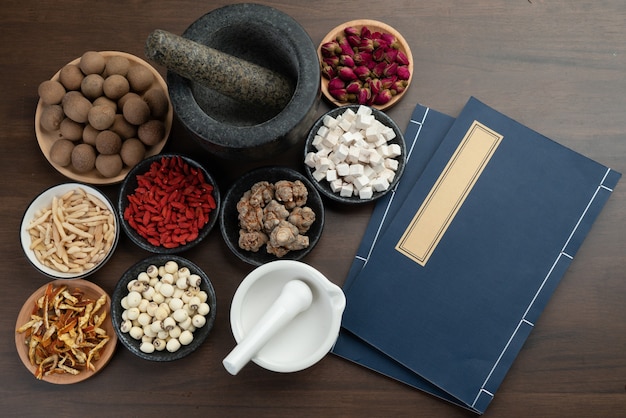 Foto antiguos libros de medicina china y hierbas sobre la mesa