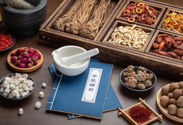 Antiguos libros de medicina china y hierbas sobre la mesa
