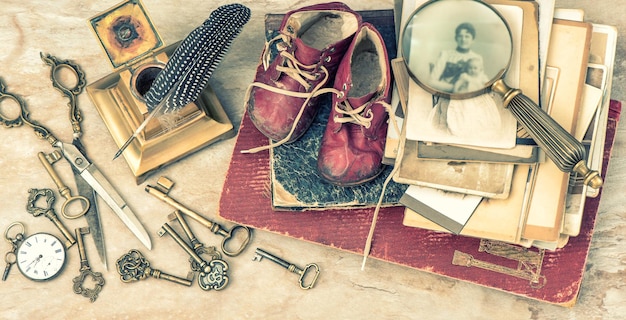 Antike Bücher und Fotos Schlüssel Babyschuhe und Schreibaccessoires Vintage-Stil