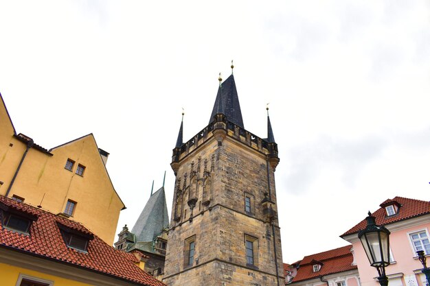 antike Gebäude mit bunten Wänden mittelalterlicher Turm mit blauer Spitze und Straßenlantern Prag Tschechisch