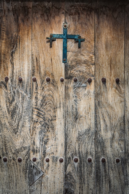 Antike holztür, verziert mit einem gusseisenkreuz und eisenstiften