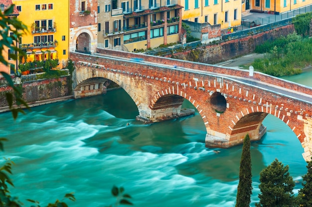 Foto antike römische brücke ponte pietra und die etsch am abend, blick vom piazzale castel san pietro, verona, italien