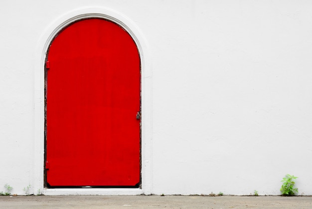 Antike rote Tür an einer weißen Betonmauer