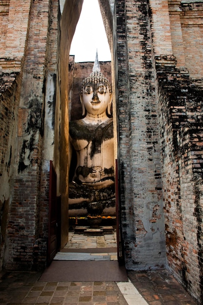 Antike Ruinen Gebäude des Tempels Wat Si Chum und antike Pra Ajana Buddha-Statuen für thailändische Menschen reisen besuchen Respekt beten im Sukhothai Historical Park World Heritage Site in Sukhothai Thailand