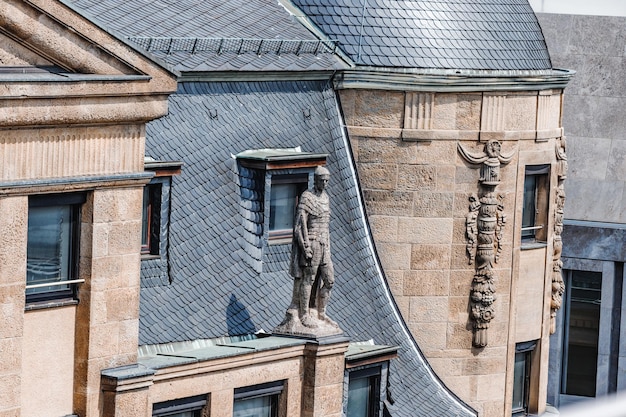 Antike Skulpturen und Statuen an der Dachfassade des Rathauses der Kölner Altstadt mit Kriegern und königlichem Adel