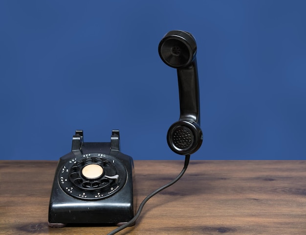 Antikes altes Telefon mit Wählscheibe auf Holztisch