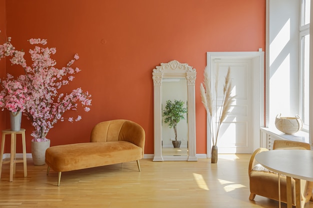 Antikes Vintage-Interieur im Wohnzimmer im Stil des 19. Jahrhunderts mit leuchtend roten Wänden, Holzboden und direktem Sonnenlicht im Zimmer.