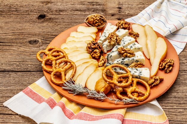 Antipasti de queijo com queijo azul e defumado, bolachas, mel, nozes e pêra madura. Receita de lanche tradicional