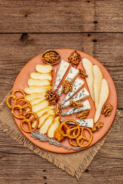 Antipasti de queijo com queijo azul e defumado, bolachas, mel, nozes e pêra madura