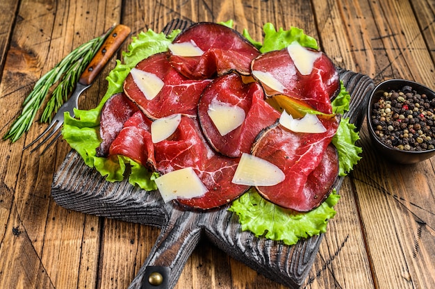 Antipasti italiano Bresaola carne cortada con ensalada verde y parmesano