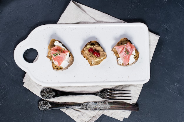 Antipasti italiano con paté, parma y salami sobre tostadas.