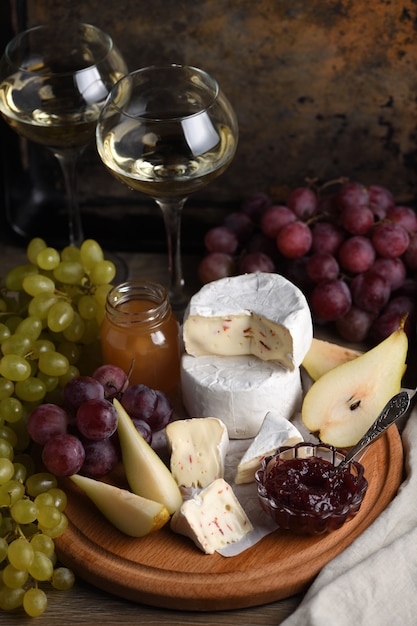 Antipasti. Queijo camembert com uvas, peras fatiadas e confeitaria, um ótimo aperitivo para vinhos.