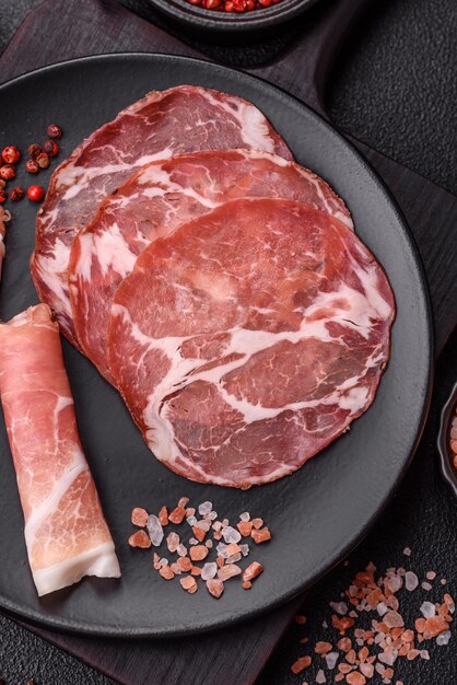 Antipasto jamon prosciutto salchicha en rodajas con tomate sal y especias