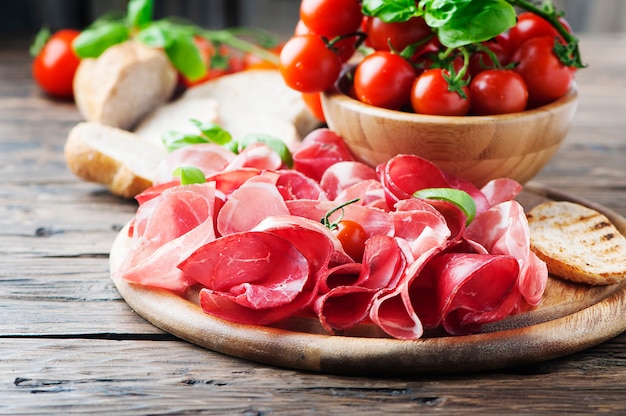 Antipasto con jamón y tomate.