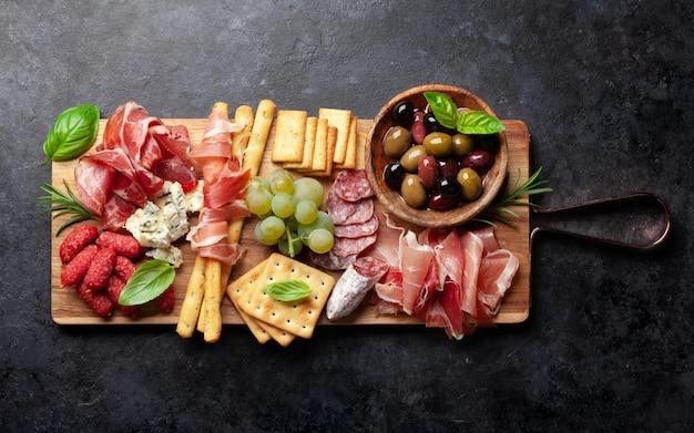 Antipasto con prosciutto salami crackers queso y aceitunas