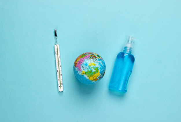 Antiseptische Flasche, Thermometer und Globus auf Blau