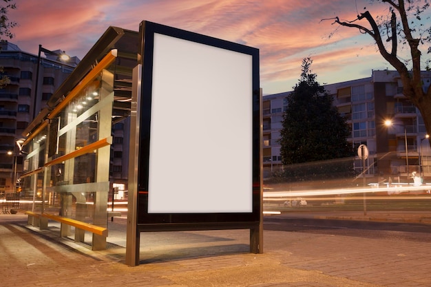 Foto anuncio en blanco en una parada de autobús con semáforos borrosos