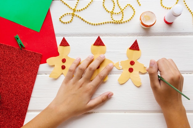 Anwendung für Kinder. Weihnachts- oder Neujahrskarte mit Lebkuchenmann aus Papier. Heimwerken.