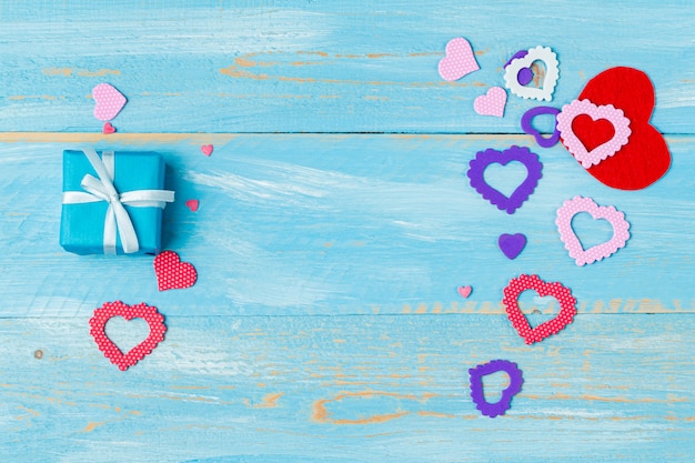 Anwesende Geschenkbox mit Herzen für Valentinstag auf dem blauen hölzernen Hintergrund mit copyspace