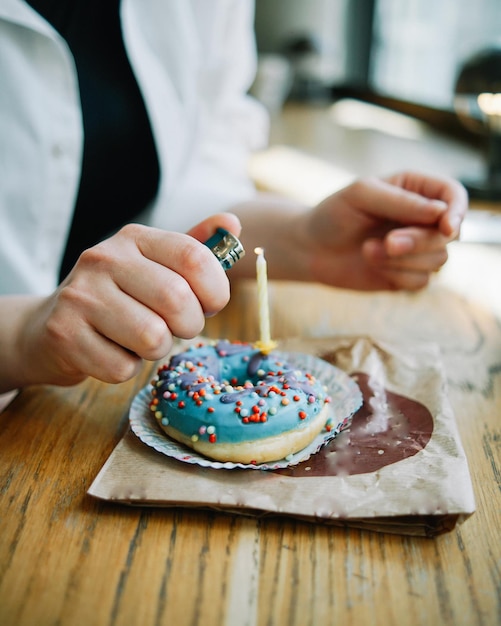 Anzünden einer Kerze auf einem Donut Einsamer Geburtstag