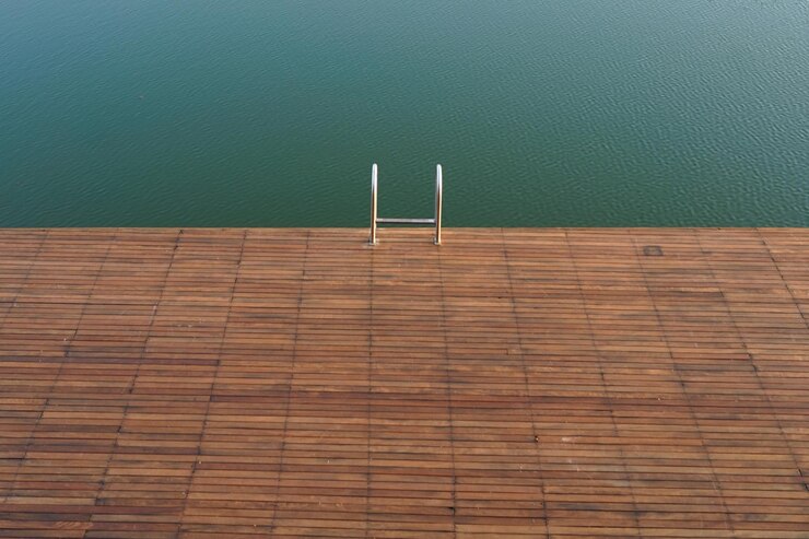 Foto ao lado da piscina com corrimão metálico