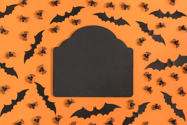 Ao redor são decorados com aranhas decorativas e morcegos de halloween.