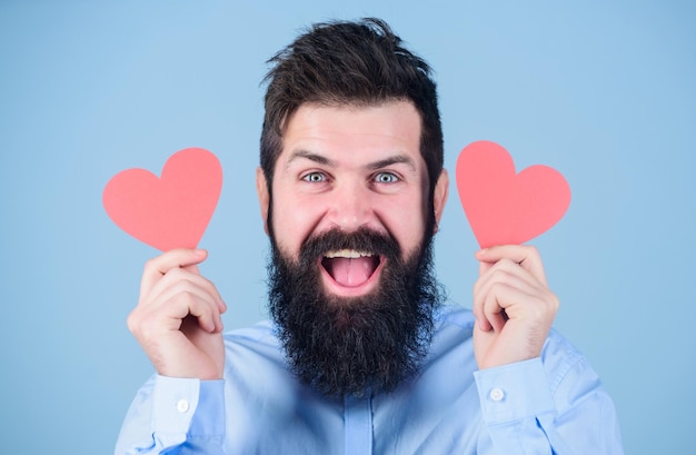Foto apaixonar-se homem barbudo hipster com cartão de dia dos namorados de coração comemore o amor cara atraente com barba e bigode em clima romântico sentindo o amor conceito de namoro e relações feliz no amor