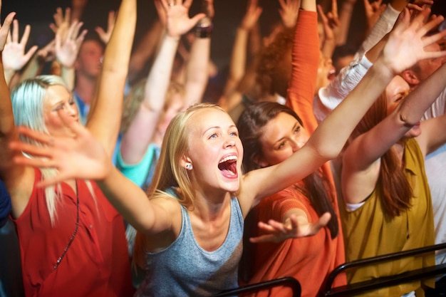 Apanhados na vibe Um grande grupo de fãs gritando em um show de rock