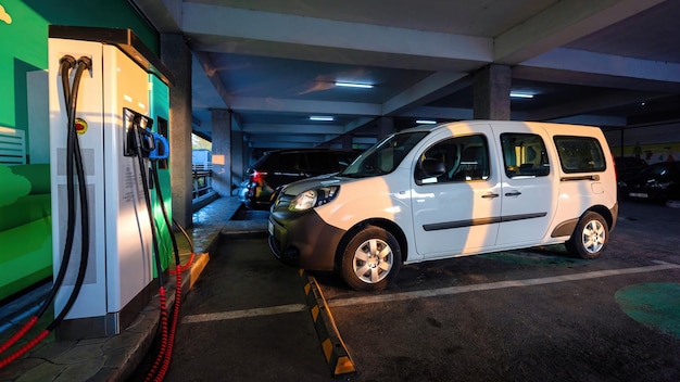 Aparcamiento con coches y estación de carga de coches eléctricos.