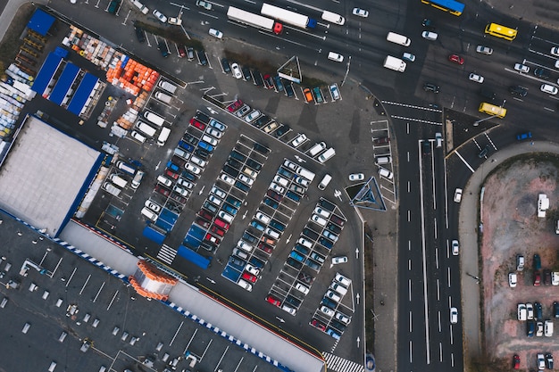 Aparcamiento en el estacionamiento de asfalto cerca del supermercado y la pista del automóvil. Estacionamiento exterior con diferentes venículas. Concepto de estacionamiento.