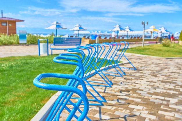 Aparcamientos para bicicletas en el frente del océano en el fondo de sombrillas de playa