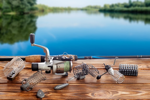 Aparejos de pesca y accesorios en la mesa contra el de un río.