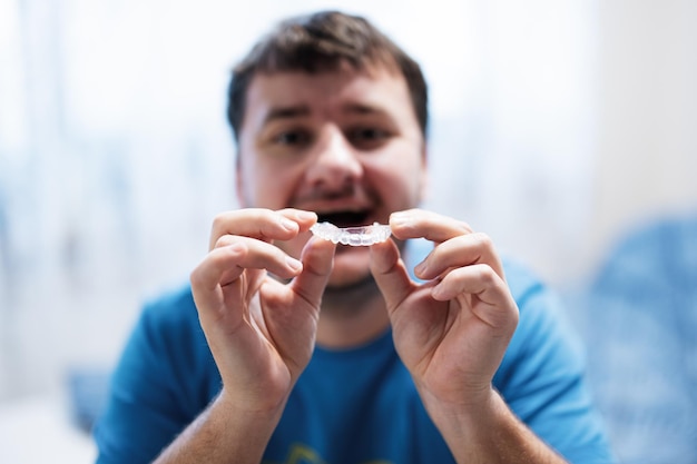 Aparelho ortodôntico móvel para correção dentária Homem usando aparelho ortodôntico de silicone ou alinhador de aparelho invisível