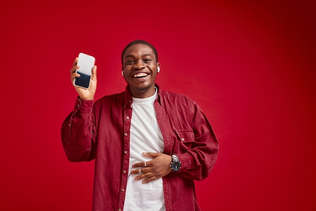 Aparência africana de homem emocional com telefone nas mãos alegria de comunicação de tecnologia