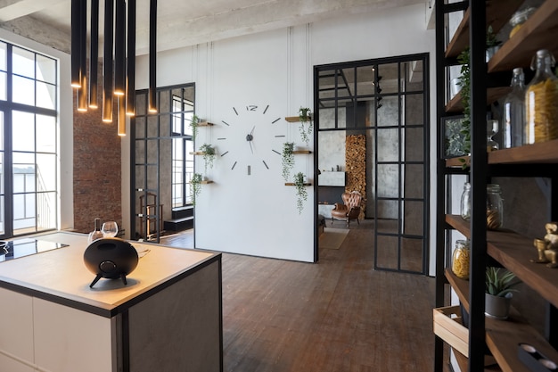 Apartamento de luxo em estilo loft em cores escuras. Cozinha moderna com ilha