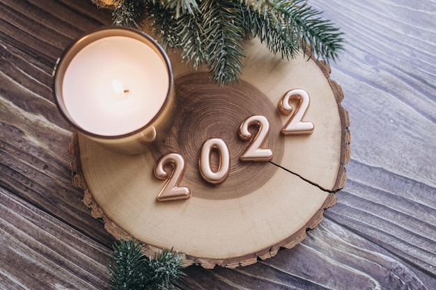 Apartamento de Natal colocado em uma mesa de madeira com números dourados de 2022 e decoração de ano novo