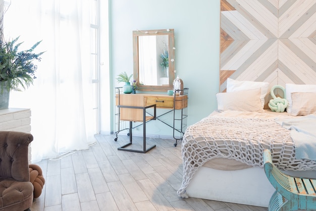 Apartamento espacioso de moda con un diseño elegante en colores pastel verde, gris y blanco con ventana grande y paredes decorativas. espacio de dormitorio y cocina