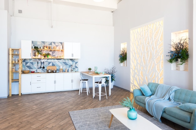 Apartamento espacioso de moda con un diseño elegante en colores pastel verde, gris y blanco con ventana grande y paredes decorativas. espacio de dormitorio y cocina