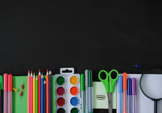 Apartamento leigos com material escolar em fundo preto.