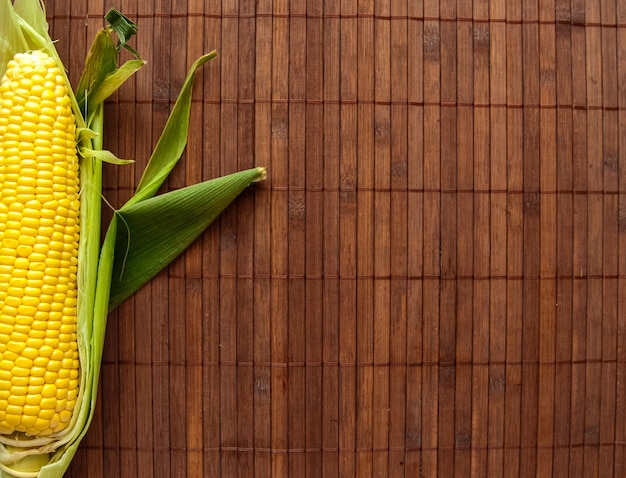 Apartamento leigos de milho amarelo brilhante sobre o fundo de madeira, conceito de estilo de vida saudável, refeição vegetariana