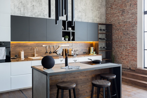 Foto apartamento de lujo en estilo loft en colores oscuros. área de cocina moderna y elegante con una isla