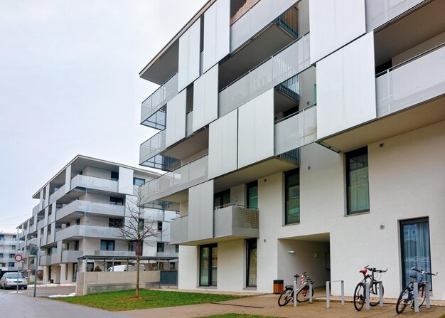 Apartamento residencial moderno e exterior de edifícios planos em Salzburgo, na Áustria. Nova casa de luxo e complexo residencial. Cidade Imobiliária e arquitetura condominial. Neve na rua ao fundo