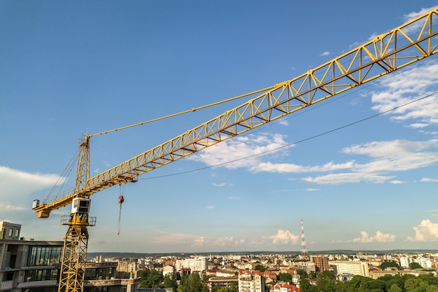 Apartment oder Büro hohes Gebäude im Bau. Backsteinmauern, Glasfenster, Gerüste und Betonstützpfeiler. Turmkran auf hellblauem Himmel kopieren Raum