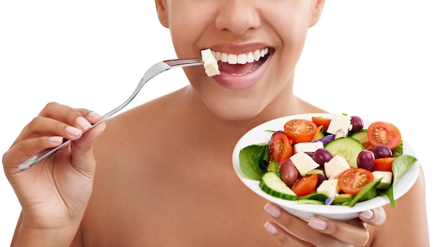 Apegarse a una ensalada hoy Foto de estudio recortada de una mujer comiendo una ensalada contra un fondo blanco