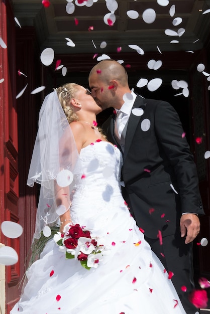 Apenas casal sob uma chuva de pétalas de rosa