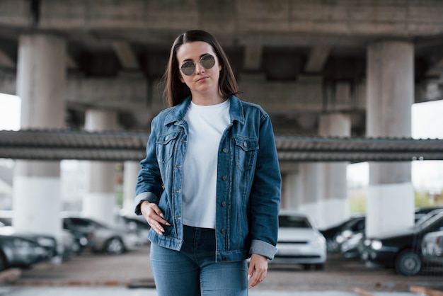 Apenas uma pessoa. Retrato de uma jovem bonita em pé sob a ponte ao ar livre