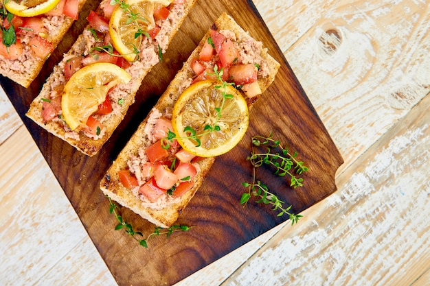 Aperitivo bruschetta con atún y tomate. Cocina italiana.